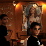 伊拉克的基督教青年进入主日礼拜堂