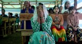 Children and their parents praying in a temporary church at a camp for internally displaced people in Myanmar.
