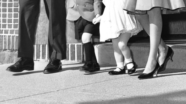 A vintage photo of a family leaving church together.