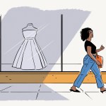 A woman walking by a store window with a wedding dress in it