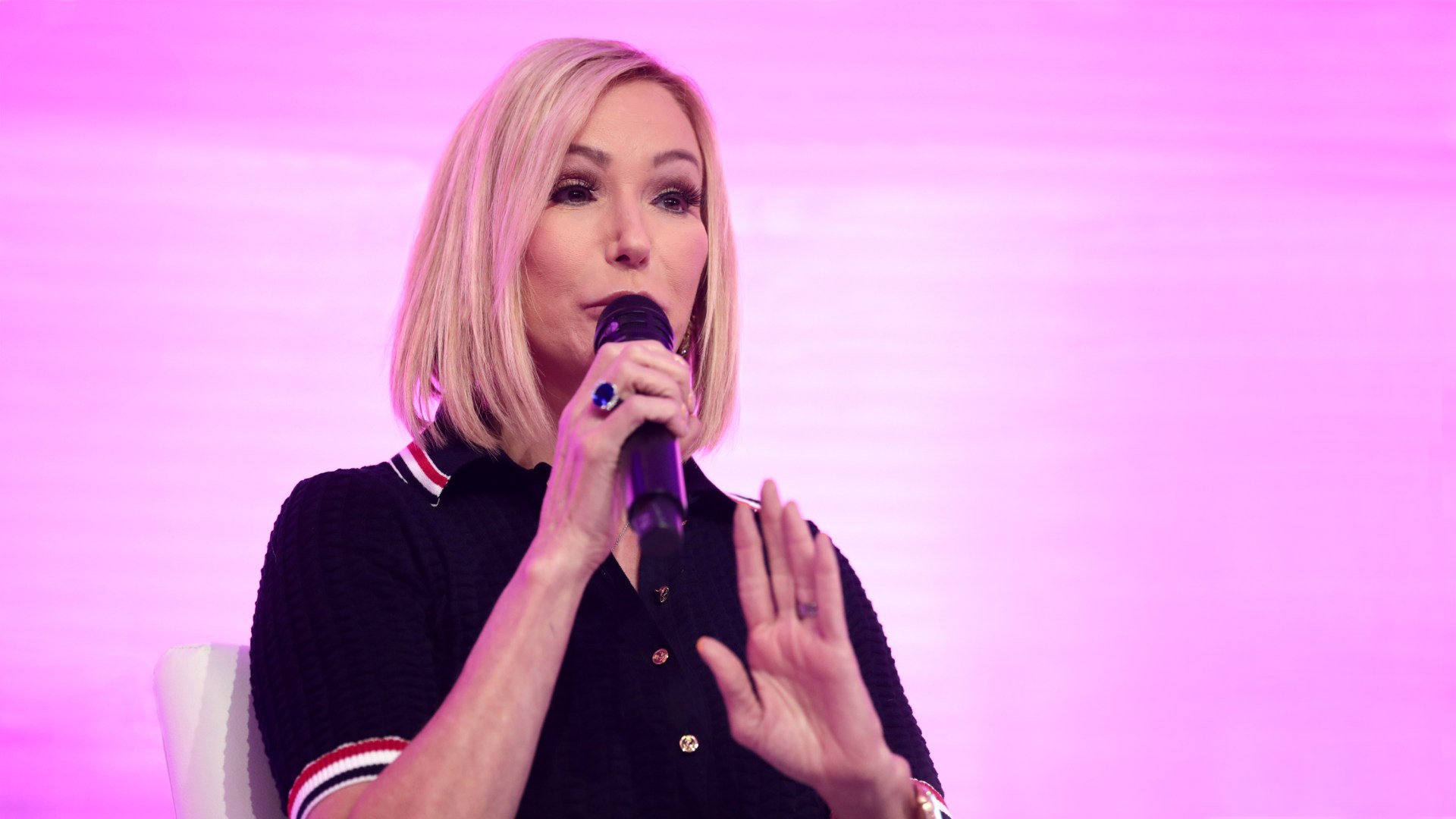 Paula White speaking in front of a pink screen