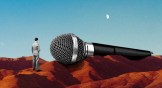 A tiny man next to a huge microphone.